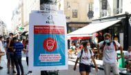Pedestrians wearing protective face masks walk by a coronavirus disease (COVID-19) information sign, as France reinforces mask-wearing as part of efforts to curb a resurgence of the coronavirus disease (COVID-19) across the country, France, August 13, 202