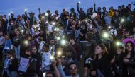 People wave their mobile phones during a protest rally against police violence during recent rallies of opposition supporters, who accuse strongman Alexander Lukashenko of falsifying the polls in the presidential election, in Minsk on August 13, 2020.  / 