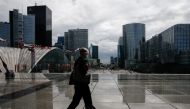 A woman wearing a protective mask walks at the financial and business district of La Defense as France reinforces mask-wearing in public places as part of efforts to curb a resurgence of the coronavirus disease (COVID-19) across the country, near Paris, F