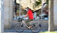 A man on a bicycle is wearing a protective mask in Dresden, Germany, April 20, 2020. REUTERS/Matthias Rietschel/File Photo