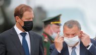 Russia's Deputy Prime Minister Yuri Borisov puts on his face mask as he stands next to Industry and Trade Minister Denis Manturov before the opening ceremony of the International military-technical forum 