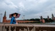 A woman wearing a face mask to protect against the coronavirus disease walks along a bridge near the Kremlin in Moscow on August 26, 2020. / AFP / Yuri KADOBNOV
