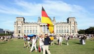 FILE PHOTO: A demonstrator holds a German flag near the Reichstag during a protest against the government's restrictions imposed over the coronavirus outbreak, in Berlin, Germany, August 1, 2020. REUTERS/Christian Mang/File Photo
