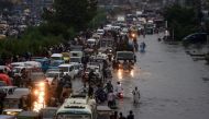 Motorists and pedestrians wade through a flooded street after heavy monsoon rains in the Pakistan's port city of Karachi on August 21, 2020. / AFP / Asif HASSAN
