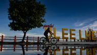 A man rides his bicycle during sunrise at Ulee Lheue beach in Banda Aceh on August 30, 2020. / AFP / CHAIDEER MAHYUDDIN