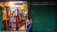 A man waits for customers at his clothing store in New Delhi on August 31, 2020. / AFP / Jewel SAMAD