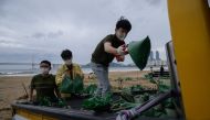 District council members fill sand bags as part of preparations ahead of the arrival of typhoon Maysak, at Gwangalli beach in Busan on September 2, 2020. / AFP / Ed JONES