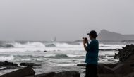 A man takes pictures along the coast as Typhoon Haishen approaches in Makurazaki, Kagoshima prefecture on September 6, 2020. / AFP / CHARLY TRIBALLEAU