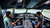 This photograph taken on September 1, 2020 shows visitors sitting in the cockpit of a retired Airbus 330 air-plane turned into a coffee shop at an attraction site, outside Pattaya in Chonburi province. With millions around the world stuck at home due to t