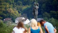 People look at the new bronze statue of U.S first lady Melania Trump in Rozno, near her hometown of Sevnica, Slovenia, September 15, 2020. REUTERS/Borut Zivulovic
