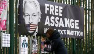 FILE PHOTO: A supporter of WikiLeaks founder Julian Assange posts a sign on the Woolwich Crown Court fence, ahead of a hearing to decide whether Assange should be extradited to the United States, in London, Britain February 25, 2020. REUTERS/Henry Nicholl