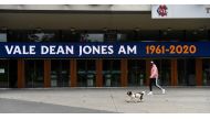 A pedestrian walks past a sign at the Melbourne Cricket Ground (MCG) remembering former Australian Cricketer Dean Jones in Melbourne on September 25, 2020 after he died the day before aged 59. / AFP / William WEST
