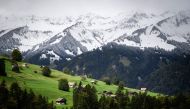 This photograph taken on September 26, 2020 shows chalets near fresh snow in Kiental, Bernese Oberland as cold winds and a sharp drop in temperatures have brought the first signs of winter to the Swiss Alps. / AFP / Fabrice COFFRINI
