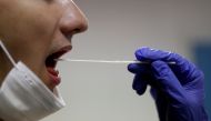 FILE PHOTO: A firefighter from the Marins-Pompiers of Marseille (Marseille Naval Fire Battalion) takes a saliva sample from a colleague who is being tested for the coronavirus disease (COVID-19) at their fire station in Marseille, France, September 22, 20