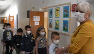 Montenegrin schoolchildren wearing protective masks to prevent the spread of the novel coronavirus (Covid-19) wait in line with their teacher on the first day of the new school year in Podgorica, on September 30, 2020. / AFP / Savo Prelevic 