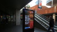 A man wearing a face mask or covering due to the COVID-19 pandemic, walks past a digital sign advising pedestrians of the Government's latest coronavirus guidance, in Liverpool, north west England on October 1, 2020, as Britain's Health Secretary Matt Han