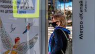 A woman wearing a face mask to protect against the coronavirus disease stands at a bus stop in central Moscow on October 5, 2020. / AFP / Yuri KADOBNOV