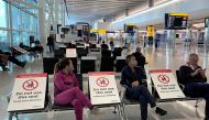 FILE PHOTO: People sit amongst socially-distanced seating signs at Heathrow Airport, as the spread of the coronavirus disease (COVID-19) continues, in London, Britain, May 10, 2020. REUTERS/Toby Melville/File Photo
