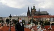 A man wearing a face mask walks across the medieval Charles Bridge as the spread of the coronavirus disease (COVID-19) continues in Prague, Czech Republic, October 7, 2020. Reuters/David W Cerny