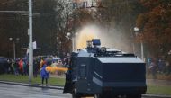 Belarusian law enforcement members use a water cannon to disperse a crowd during an opposition rally to reject the presidential election results in Minsk, Belarus October 11, 2020. REUTERS/Stringer
