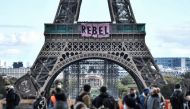 Activists of environmental protest group Extinction Rebellion (XR) deploy banners to read 