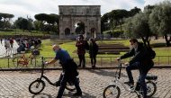 People wearing face masks are seen next to the Arch of Constantine as Italy adopts new restrictions aimed at curbing a surge in the coronavirus disease (COVID-19) infections, in Rome, Italy October 13, 2020. REUTERS/Guglielmo Mangiapane