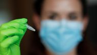 A biologist shows a EasyCOV rapid salivary test which displays yellow reagent positive at the Covid-19 disease, in Paris, France, October 12, 2020. Picture taken October 12, 2020. REUTERS/Benoit Tessier