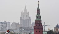 A woman wearing a face mask to protect against the coronavirus disease walks along a bridge in front of a tower of the Kremlin and the Russian Foreign Ministry building on the background in central Moscow on October 13, 2020. / AFP / Yuri KADOBNOV