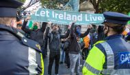 Demonstrators hold a banner during a protest against the Irish government imposed restrictions put in place to help stem the rise in the number of novel coronavirus COVID-19 cases, outside Leinster House in Dublin on October 10, 2020.