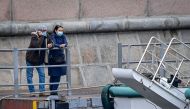 People wearing face masks to protect against the coronavirus disease stand on a pier as they wait for a pleasure boat in central Moscow on October 13, 2020. / AFP / Yuri KADOBNOV