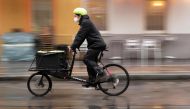 Marcus Hanould, 25 year's old bicycle courier of Veloce company, rides his bike to a residential building to deliver Covid-19 tests and bring them back to a lab in Vienna, Austria on October 13, 2020. / AFP / JOE KLAMAR
