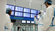 Health workers wearing protective gear wait for passengers to be tested for COVID-19 on arrival at Charles de Gaulle airport amid the coronavirus disease (COVID-19) outbreak, in Roissy, near Paris, France July 31, 2020. REUTERS/Christian Hartmann/File Pho