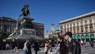 People wearing protective masks walk across the Piazza del Duomo in Milan on October 17, 2020, amid the Covid-19 pandemic. AFP / MIGUEL MEDINA