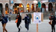 People wearing protective masks walk in an area of mandatory mask use, ahead of a curfew imposed by local authorities in the university town of Louvain-La-Neuve amid the coronavirus disease (COVID-19) outbreak, in Belgium, October 13, 2020. REUTERS/Franco