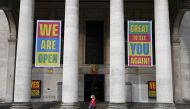 A pedestrian walks past the entrance to central library in Manchester, northwest England as the country battles a surge in coronavirus cases on October 19, 2020 / AFP / Paul ELLIS