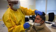 A healthcare worker takes a swap from a patient to run a COVID-19 Rapid Test at the CAP Manso primary care centre in Barcelona on October 21, 2020. AFP / LLUIS GENE