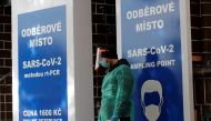 A medical staff member wearing a protective suit waits for people who will be tested for the coronavirus disease (COVID-19) in front of a recently opened sampling station inside of closed music club in Prague, Czech Republic, October 20, 2020. REUTERS/Dav