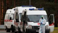 A medical specialist wearing protective gear stands next to ambulances parked outside a hospital amid the outbreak of the coronavirus disease (COVID-19) in Saint Petersburg, Russia October 23, 2020. REUTERS/Anton Vaganov