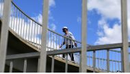 A man wearing a face mask crosses a pedestrian bridge in the Melbourne suburb of St Kilda on October 26, 2020 as Australian health officials reported no new coronavirus cases or deaths in Victoria state, which has spent months under onerous restrictions a