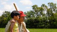 This undated handout photo obtained from the Busan International Film Festival (BIFF) in Busan on October 28, 2020 shows Korean-American actor Steven Yeun (R-red cap) in a scene from Korean immigrant drama 