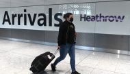 FILES) In this file photo taken on July 10, 2020 passengers wearing a face mask or covering due to the COVID-19 pandemic, arrive at Heathrow airport, west London. AFP / DANIEL LEAL-OLIVAS
