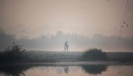 A couple has their pictures taken on the banks of the Yamuna River during a smoggy morning at sunrise in New Delhi on October 29, 2020. AFP / Jewel Samad 