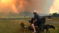 (FILES) A file photo was taken on November 12, 2019 shows locals watching as bushfires impact on farmland near the small town of Nana Glen, some 600kms north of Sydney. / AFP / William WEST
