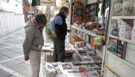 A man browses the headlines of Iranian Farsi newspapers featuring the 2020 US general election results at a news stand in Iran's capital Tehran on November 8, 2020. / AFP / ATTA KENARE