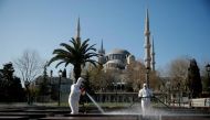 FILE PHOTO: Workers in protective suits disinfect the park in front of the Blue Mosque in response to the spread of coronavirus disease (COVID-19) in Istanbul,Turkey March 21, 2020. REUTERS/Kemal Aslan

