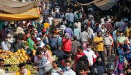 A health worker takes the temperature of shoppers at a crowded market amid the spread of the coronavirus disease (COVID-19), in Ahmedabad, India, November 20, 2020. REUTERS/Amit Dave
