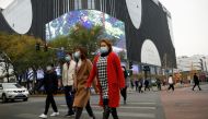 People wearing face masks walk near a shopping complex amid the coronavirus disease (COVID-19) outbreak in Beijing, China November 16, 2020. REUTERS/Tingshu Wang

