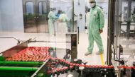 In this file photo taken on September 11, 2020 A laboratory technician supervises capped vials during filling and packaging tests for the large-scale production and supply of the University of Oxford’s COVID-19 vaccine candidate, AZD1222, conducted on a h