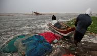 Fishermen move a fishing boat to a safer place along the shore before Cyclone Nivar's landfall, in Chennai, India, November 25, 2020. REUTERS/P. Ravikumar