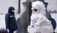 A security guard holds a thermometer at Yingqian village of Pudong district, amid the global outbreak of the coronavirus disease (COVID-19), in Shanghai, China November 25, 2020. REUTERS/Aly Song